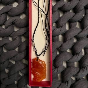 Jade wish pendant necklace on silk cord.